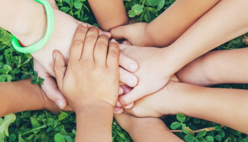 Children's,Hands,Together,On,A,Background,Of,Grass.,Selective,Focus.
